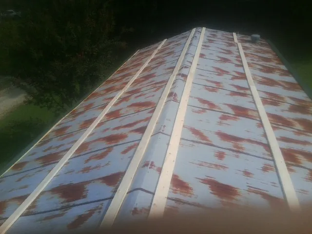 Rusted metal roof panels with new wood purlins before replacement — Storm Damage Roof Repair in Hillsborough by Roofing Brothers